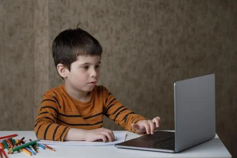 A small child is studying at the computer. Distance learning at home quarantine Stock Photos