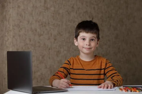 A small child is studying at the computer. Distance learning at home quarantine Stock Photos