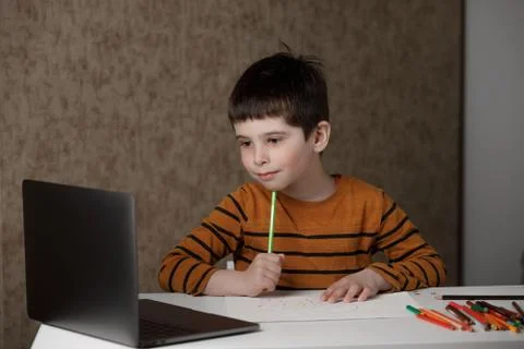 A small child is studying at the computer. Distance learning at home quarantine Stock Photos