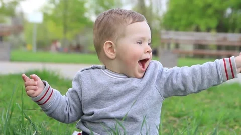 A small child is talking in the park and soap bubbles are flying around him. Video stock 201325670