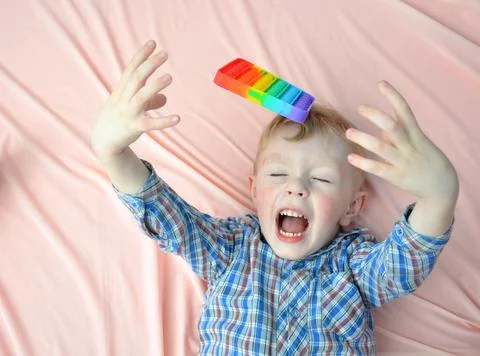 A small child throws a POP IT toy. Stock Photos
