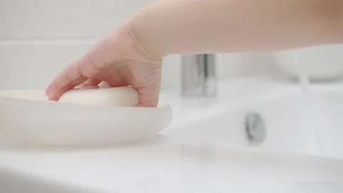 A small child tries to take soap to wash his hands, it slips out. Close-up Stock Footage 130414405