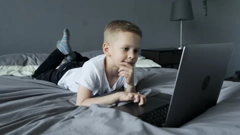 A Small Child Uses A Computer, Looks at The Laptop Screen Stock Footage 157815585