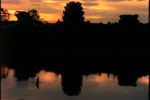 A small child wades through pools near Angkor Wat temple in Cambodia. Stock Footage