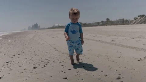 A small child walking down a sandy beach in Myrtle Beach, South Carolina Stock Footage 128614789