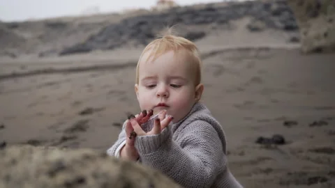 A small child walks along the sandy beach by the ocean. Stock Footage 146100458