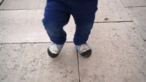 Small child walks on tiles in tiny shoes. Cropped Stock Footage 233090806