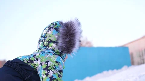 A small child walks in the winter Park. Playing and smiling baby climbs up the Vidéo 99587679