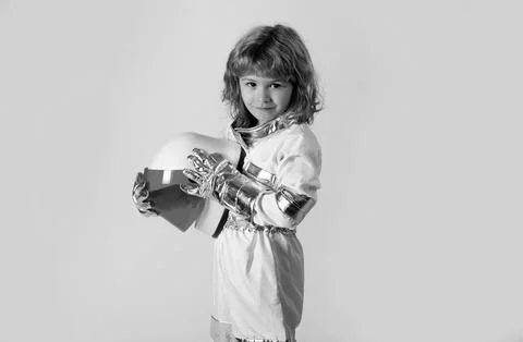 Small child wants to fly an in space holding astronaut helmet. Copy space. Stock Photos