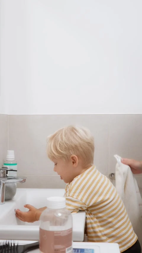 A small child washes his hands and face in the morning in the bathroom. Stock Footage 291474688