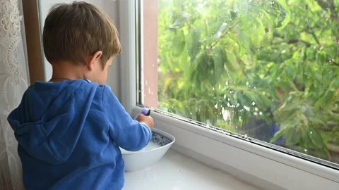 A small child washes the window. High quality video Stock Footage 141936014