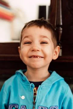 A small child without front teeth laughs merrily Stock Photos