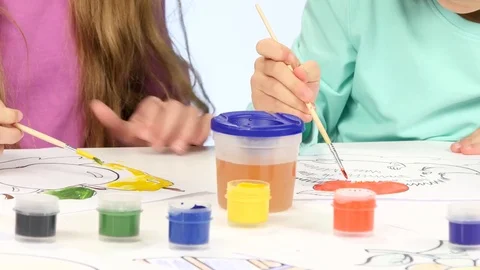 Small children with the help of brushes and paints decorate drawings, they like Stock Footage 76121395