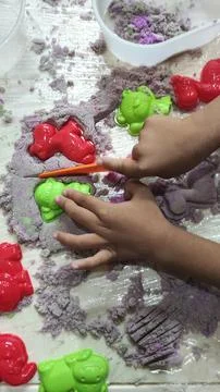 Small children, playing with colored sand. Stock Photos