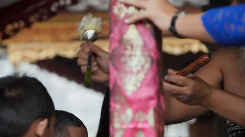 Small children receiving water blessing at Melukat Mebayuh Ceremonial in Bali Stock Footage 140297928