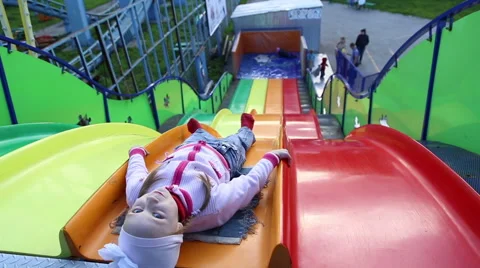 Small children ride a sliding board Stock Footage 50524399