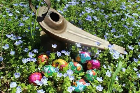 Small chocolate Easter eggs of multiple colors with decorative bunnies. Stock Photos
