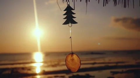 Small Christmas tree hangs on the beach with sunset view to the ocean in slow Stock-Footage 81263695