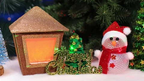 A small Christmas tree with letters between a snowman and a Christmas lantern Stock Footage 340885999