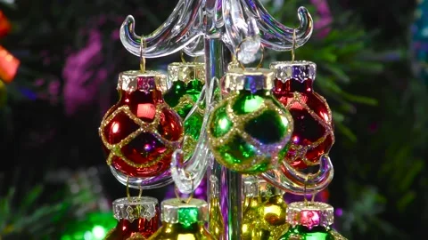 A small Christmas tree rotates between candles and a large Christmas tree Stock Footage 166840906