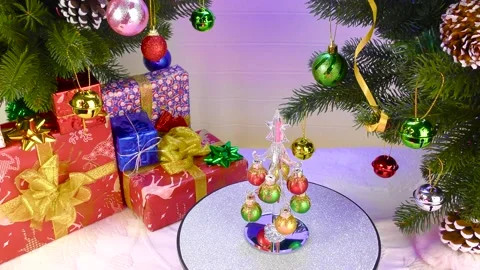 A small Christmas tree rotates between two large Christmas trees Stock Footage 221372515