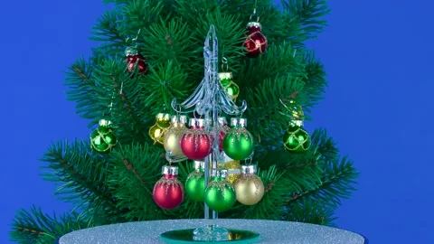 A small Christmas tree rotates near a large Christmas tree Stock Footage 220734514