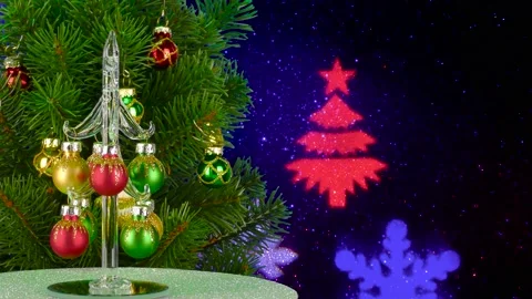 A small Christmas tree rotates near a large Christmas tree Stock Footage 220734516