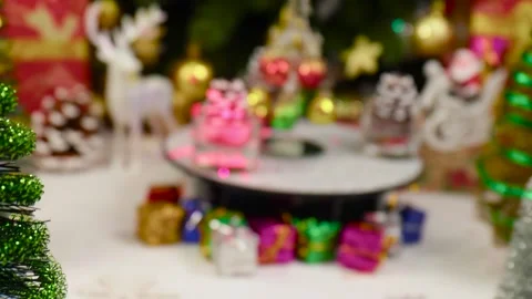 A small Christmas tree rotates on a stand surrounded by pine cones Stock Footage 260887986