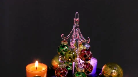 Small christmas tree surrounded by burning candles and balls in motion Stock Footage 162628252