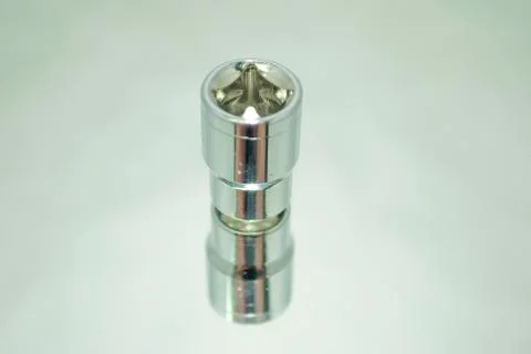 Small chrome ratchet socket on mirror close-up Stock Photos