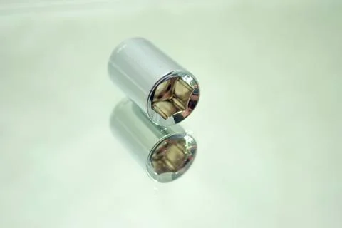 Small chrome ratchet socket on mirror close-up Stock Photos