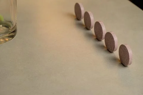 Small circular objects arranged in a neat line on a smooth surface Stock Photos