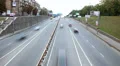Small city street time lapse, cars drive both ways, bridge HD Footage