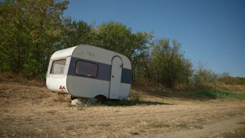 Small classic caravan parked in a sunny countryside meadow. 4K. Stock Footage 345565224