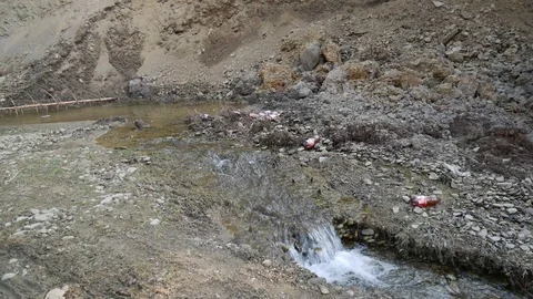 Small clean creek polluted with plastic beer bottles Stock Footage 105629937