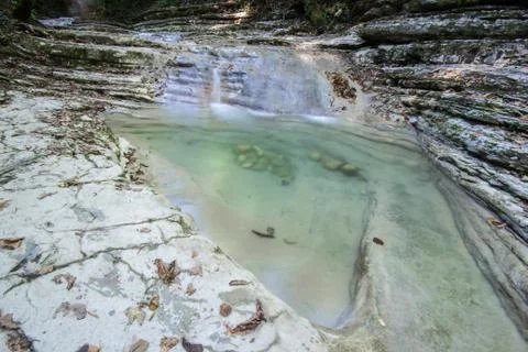 Small clean mountain river waterfall and green overgrown river banks Stock Photos