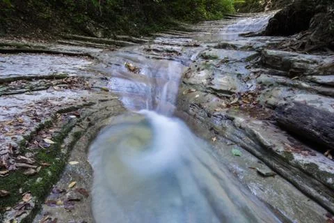 Small clean mountain river waterfall and green overgrown river banks Stock Photos