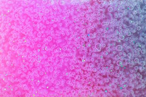 Small clear air bubbles floats in pink and purple fluid. Stock Photos