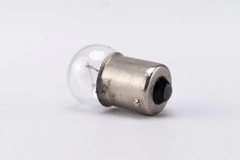 Small Clear Light Bulb with Silver Base on White Background. Stock Photos