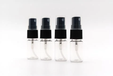 Small clear spray bottles lined up on a flat surface Stock Photos