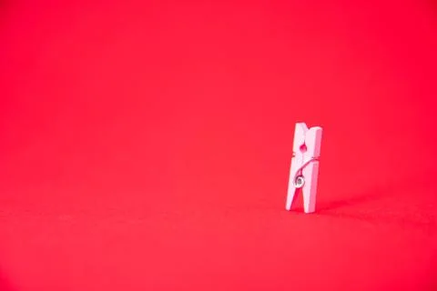 Small clothespin on red background. Close-up. Art soft focus. Stock Photos