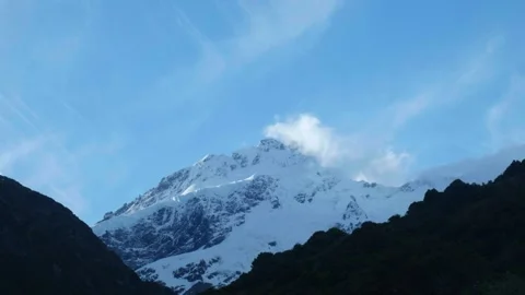 Small cloud covering the top of snowy peak Stock Footage 260369864
