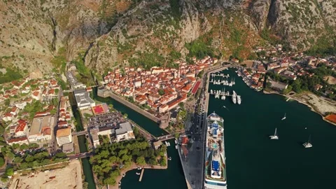 Small Coastal Town Below a Huge Rock Face Aerial Pull Back Stock Footage 345529704