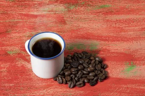Small coffee cup with roasted beans on the side Stock Photos