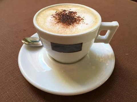 Small coffee cup with spoon on a table at a bar Stock Photos