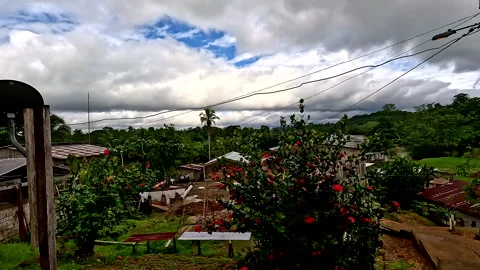 A small community build on a hillside next to a large tropical river Vidéo 336920413