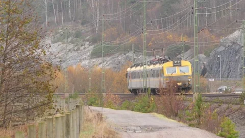 Small Commuter Train Passing By at Fall, Wide Shot Stock Footage 234983060
