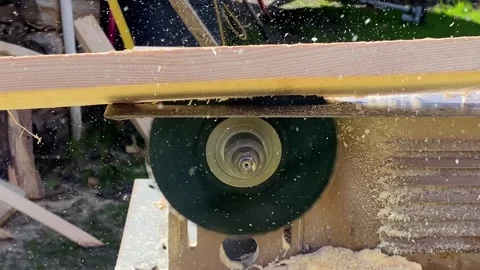 Small compact circular saw quickly cuts along wooden board. Wood dust sawdust Vídeo Stock 243939469