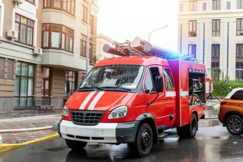 Small compact fire engine truck with ladder and safety equipment at accident in Stock Photos