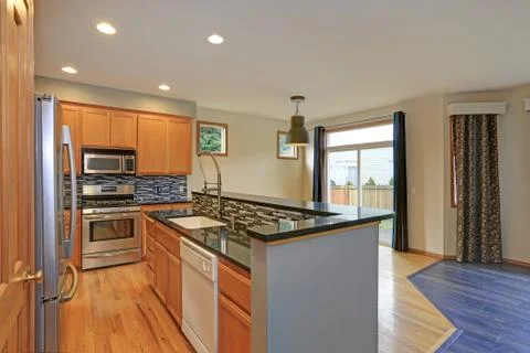 Small compact kitchen room with light wood cabinetry, Quartz counters and din Stock Photos